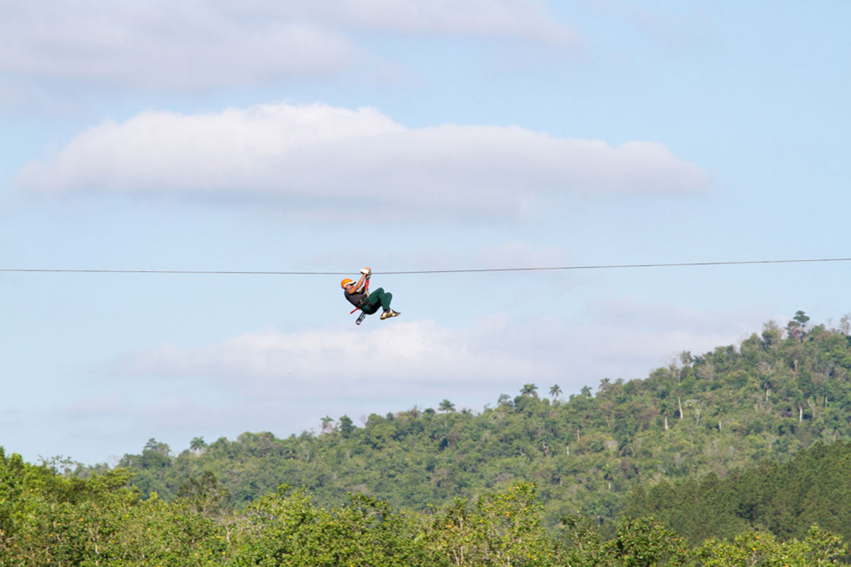 A traveller seen having an amazing time soaring above the canopy on a zip line